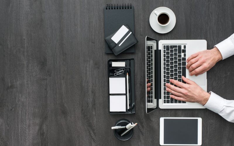 黒いテーブルでPCを操作する男性の手元とTエンジニア採用に適した企業の仕事環境イメージ